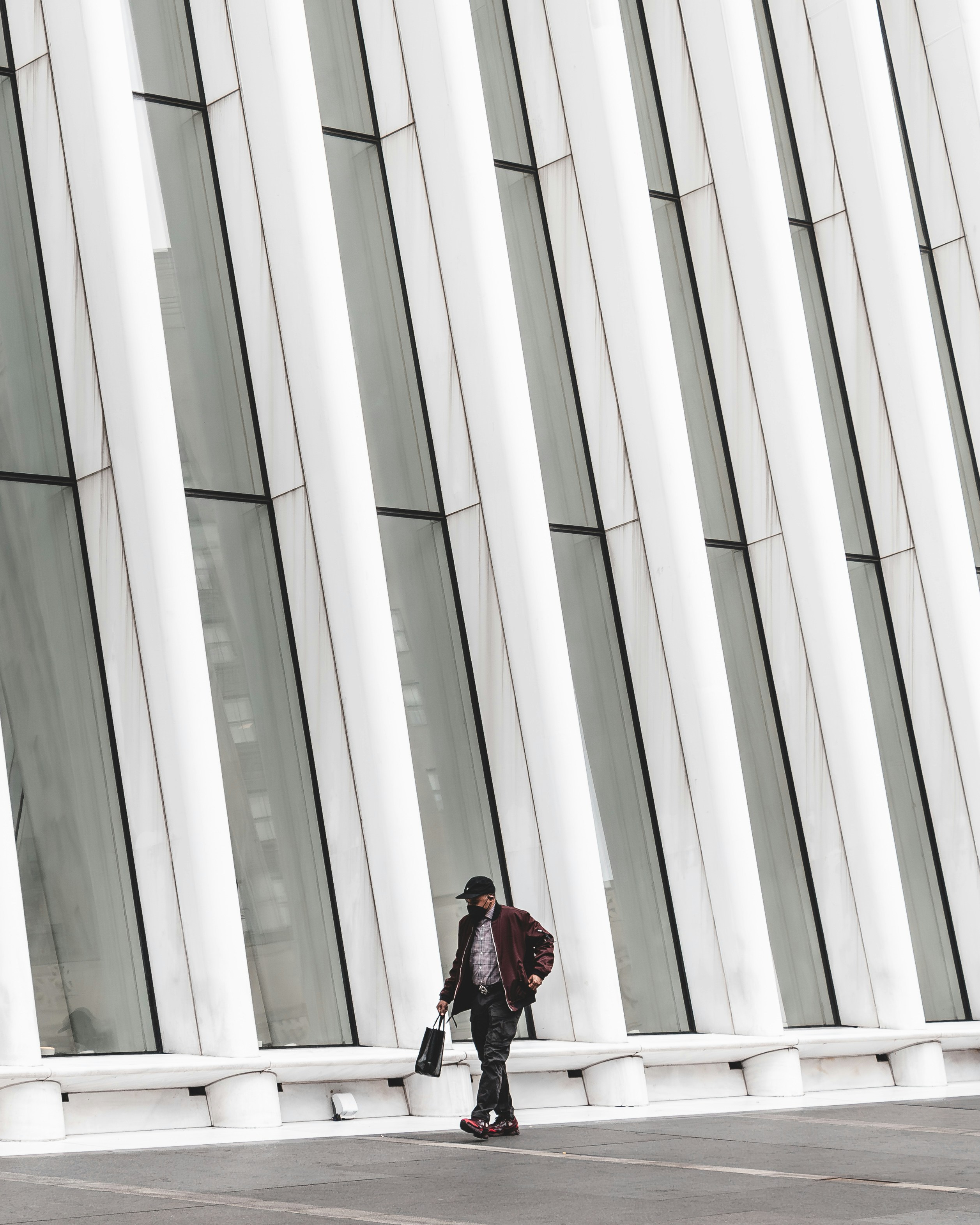 Un uomo che cammina davanti a un alto edificio bianco