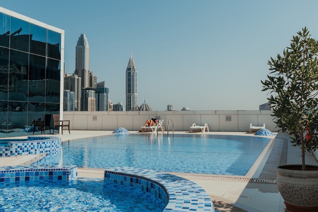 A large swimming pool with a view of a city, Rooftop swimming pool with modern cityscape views