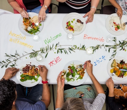 A group of people sitting around a table with plates of food