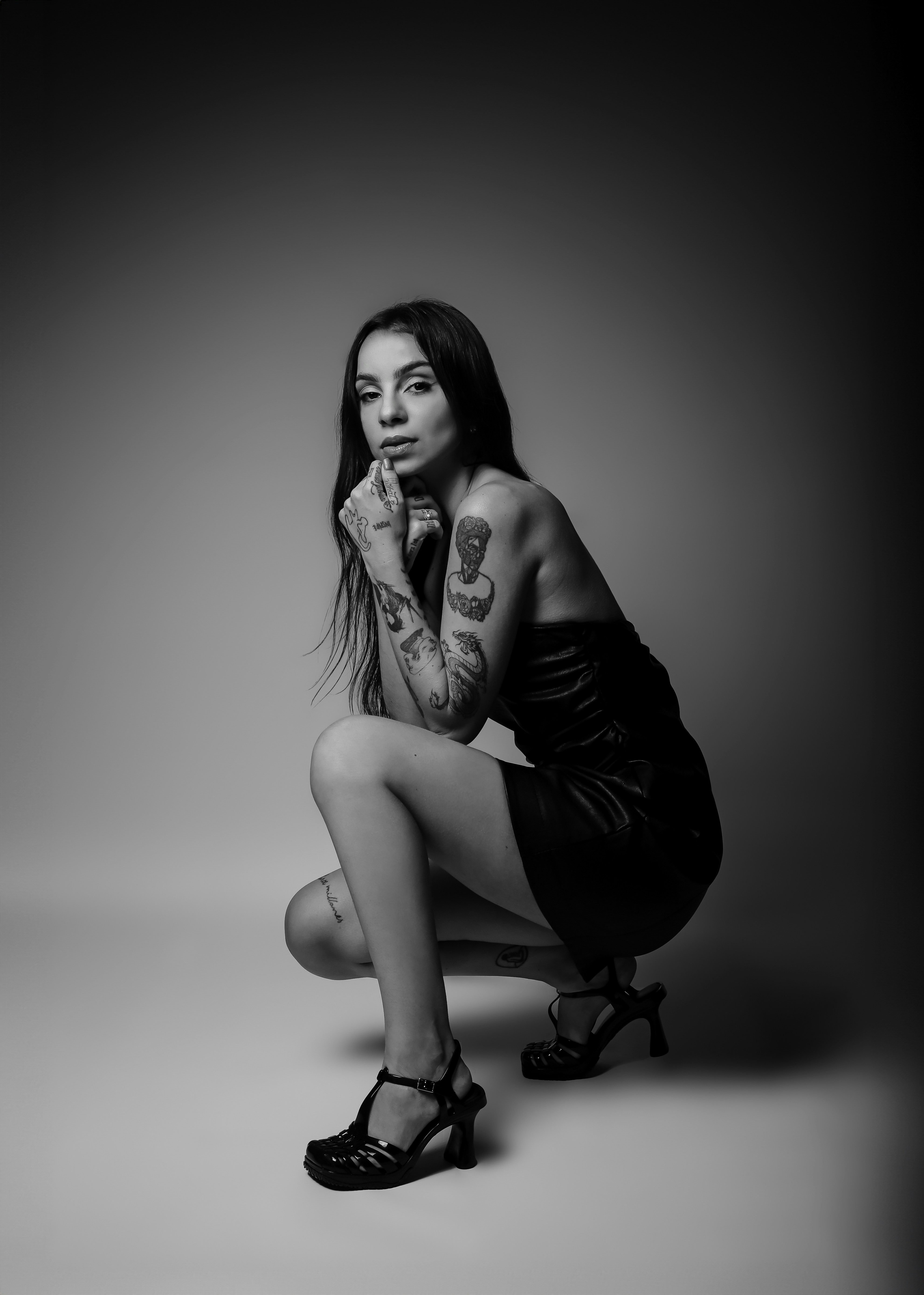 A black and white photo of a woman with tattoos