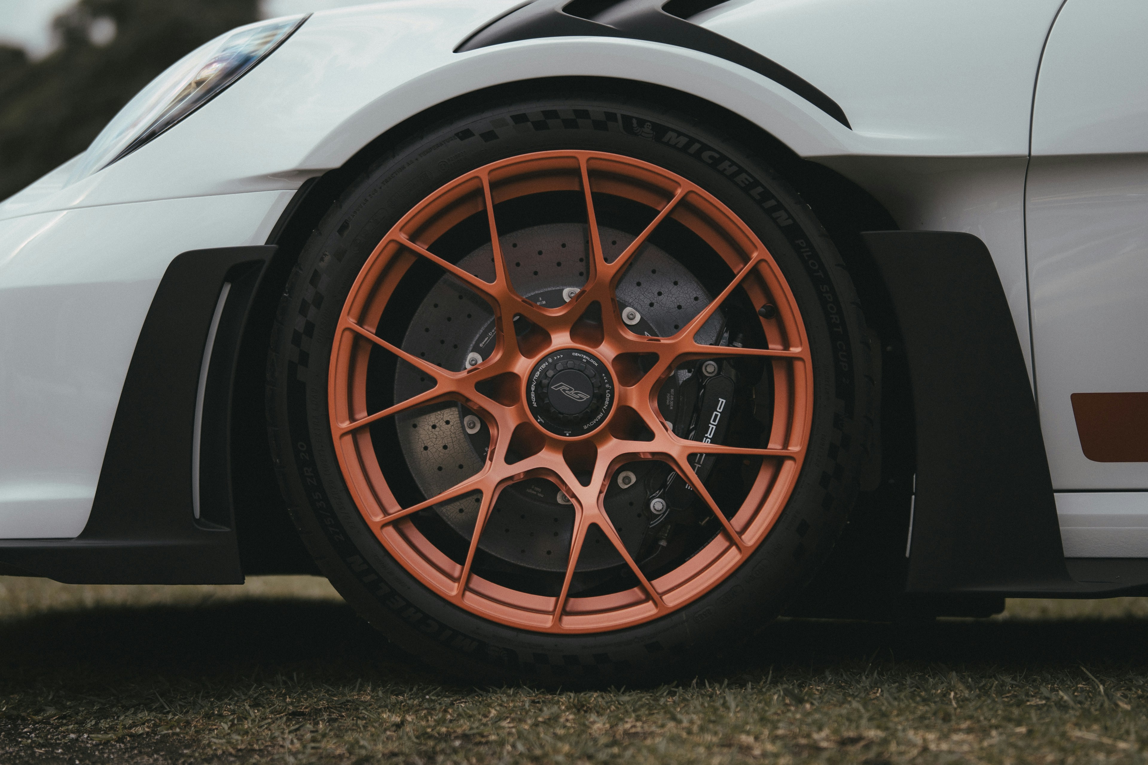 A white and orange sports car parked in a field