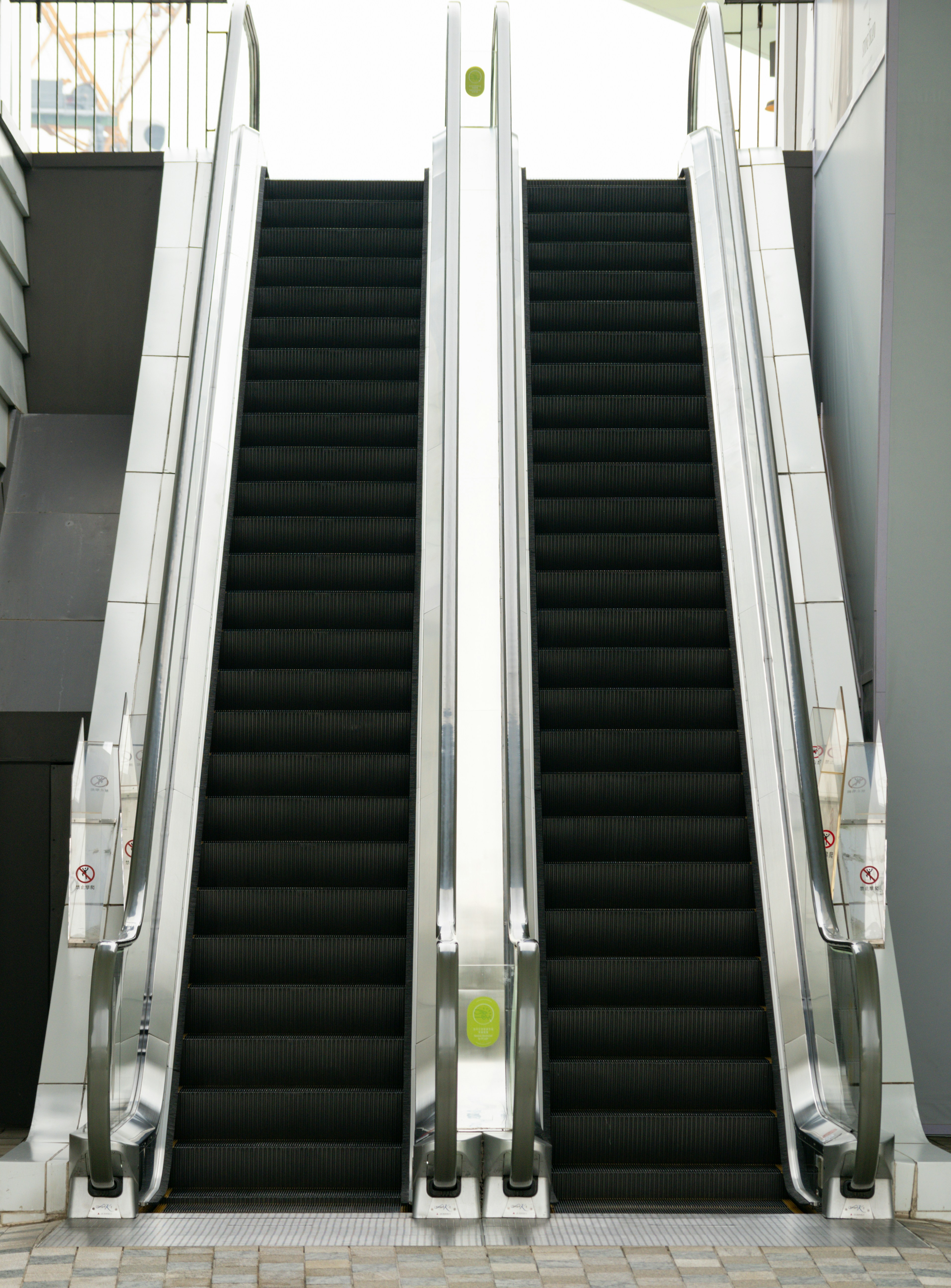 Uma escada rolante em um prédio com duas pessoas