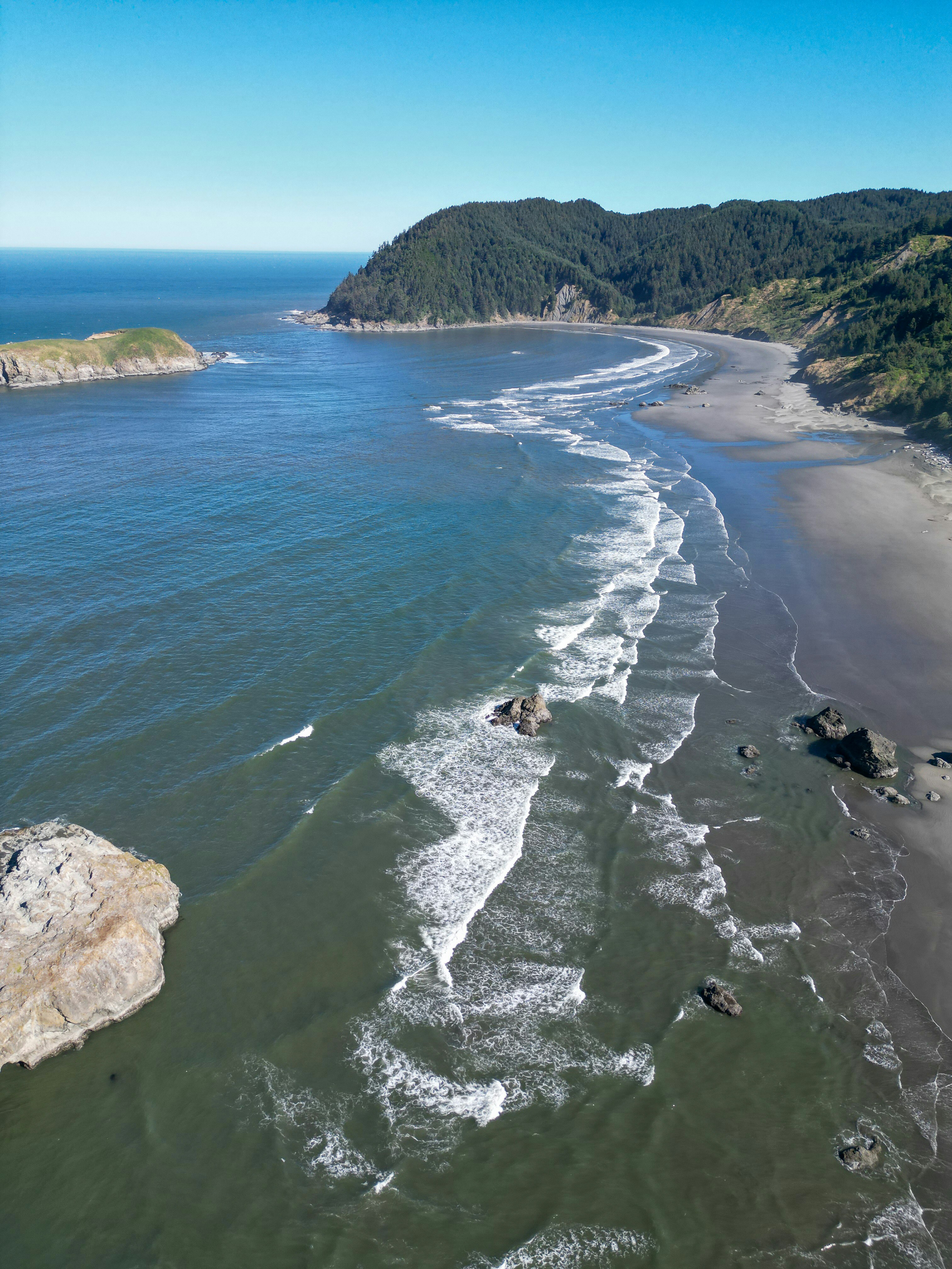 An aerial view of a beach with waves coming in