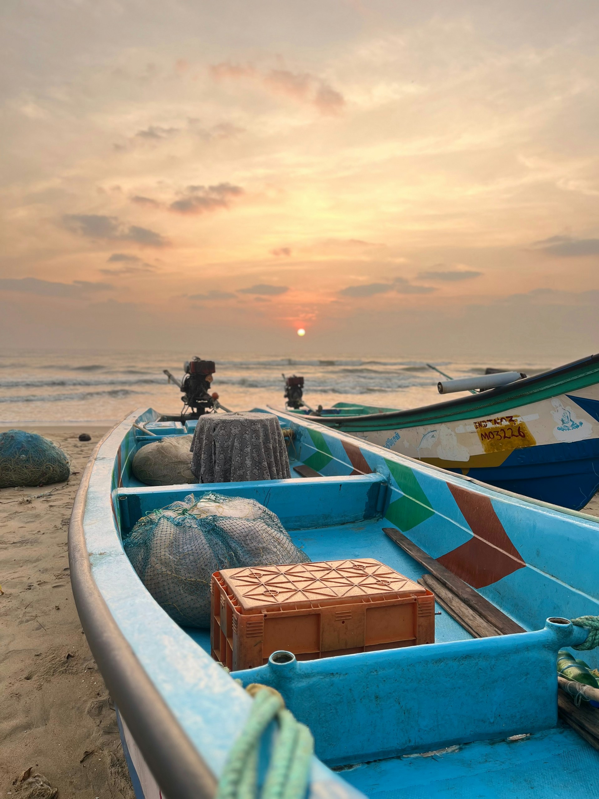 A blue boat sitting on top of a sandy beach