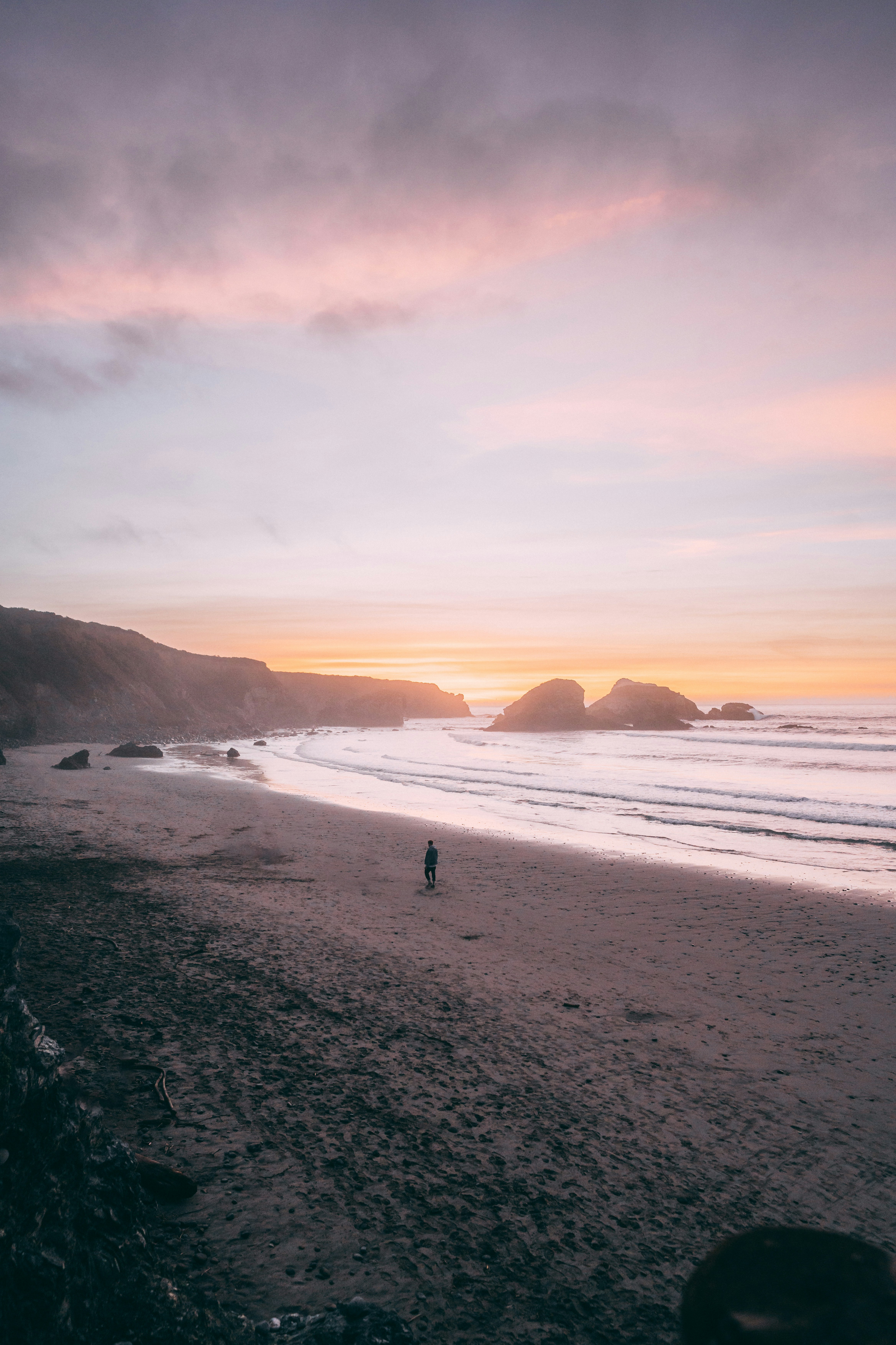 Eine Person, die bei Sonnenuntergang an einem Strand spazieren geht
