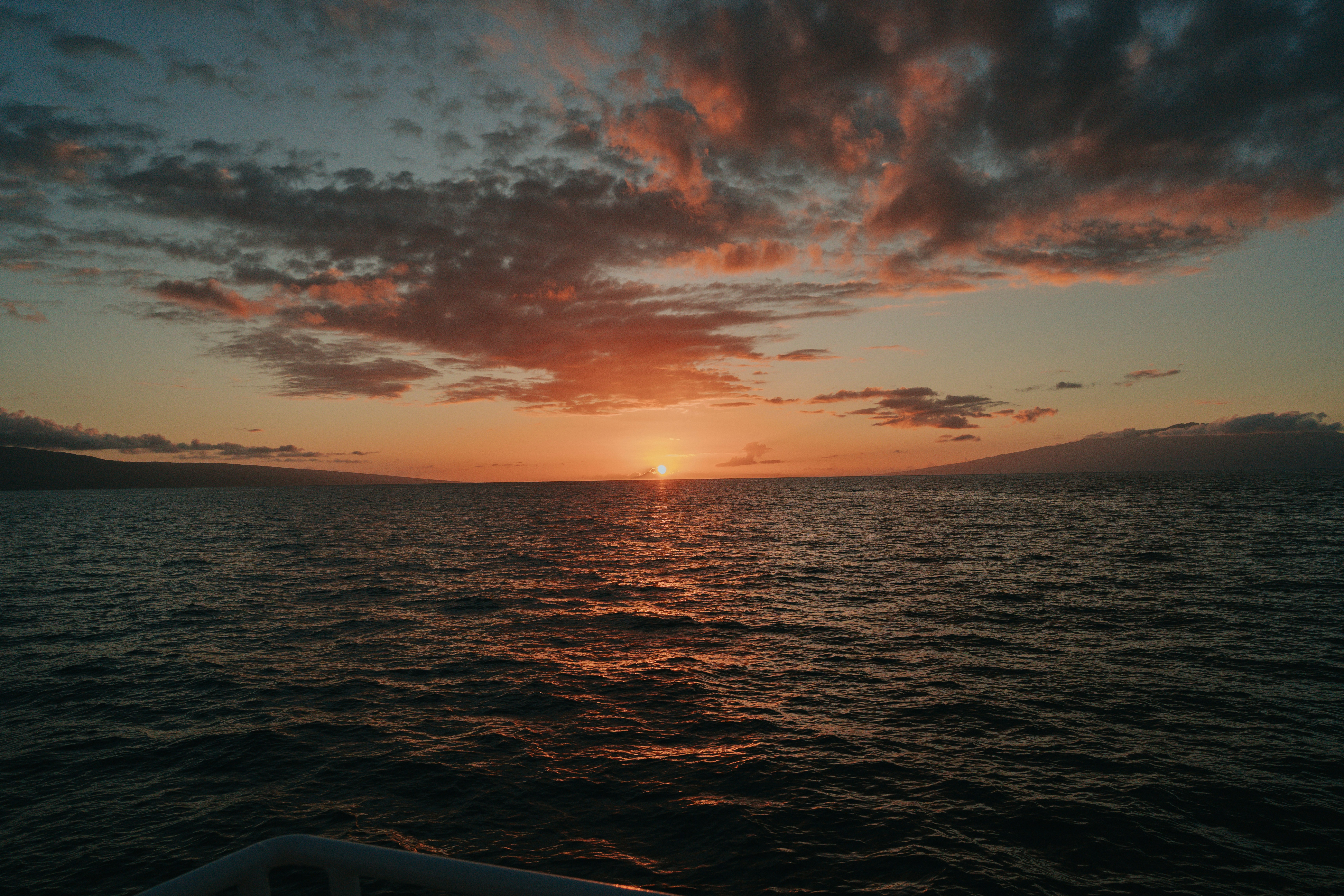 Die Sonne geht über dem Ozean unter, wie von einem Boot aus gesehen
