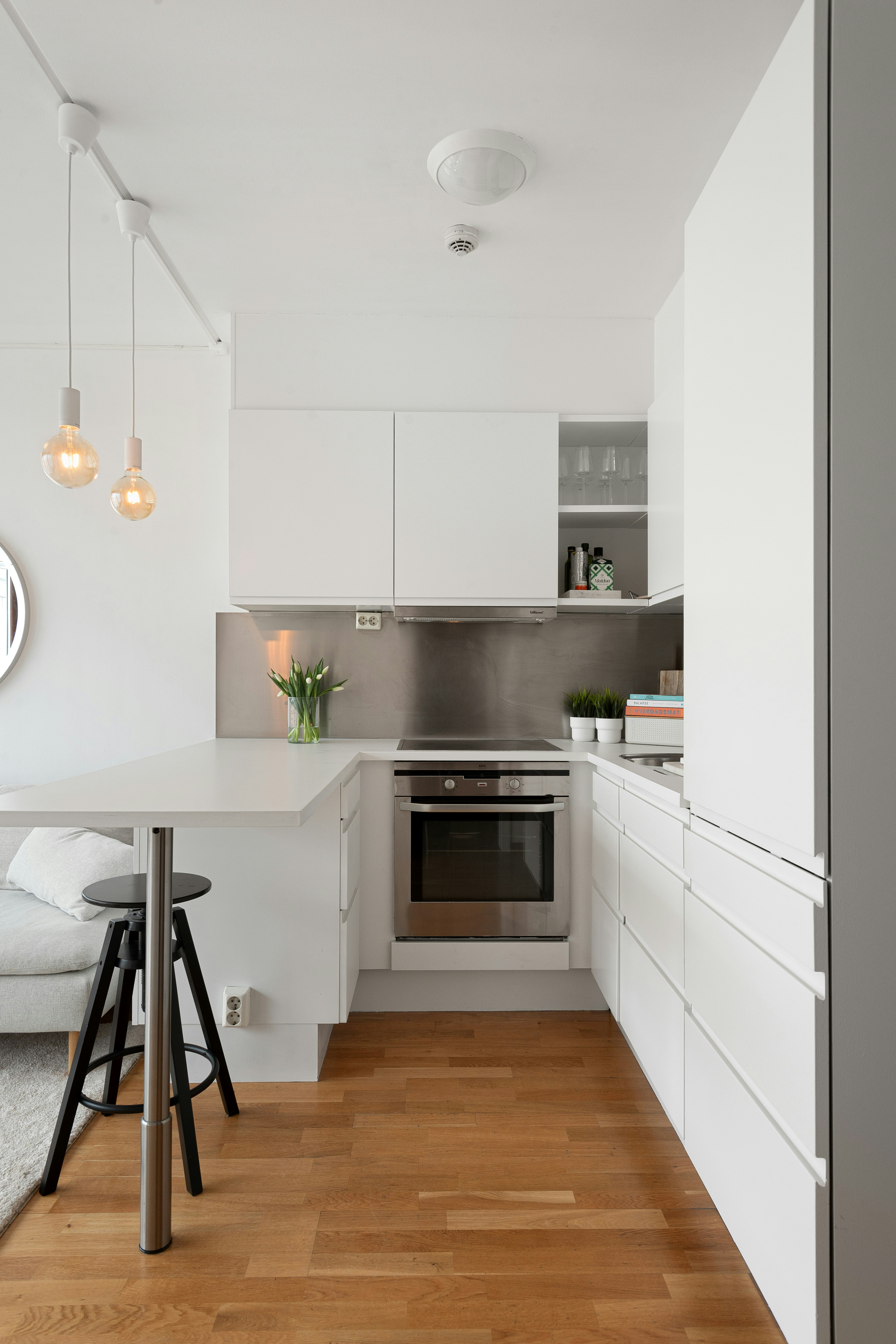 A kitchen with white cabinets and a bar stool