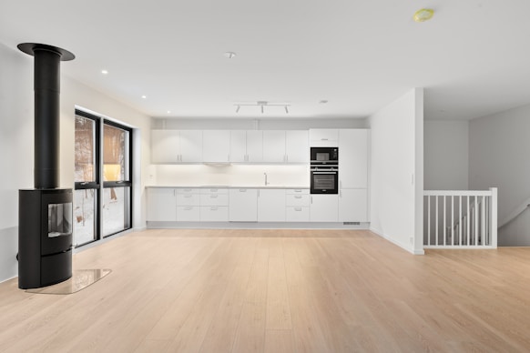 An empty room with a wood floor and white walls