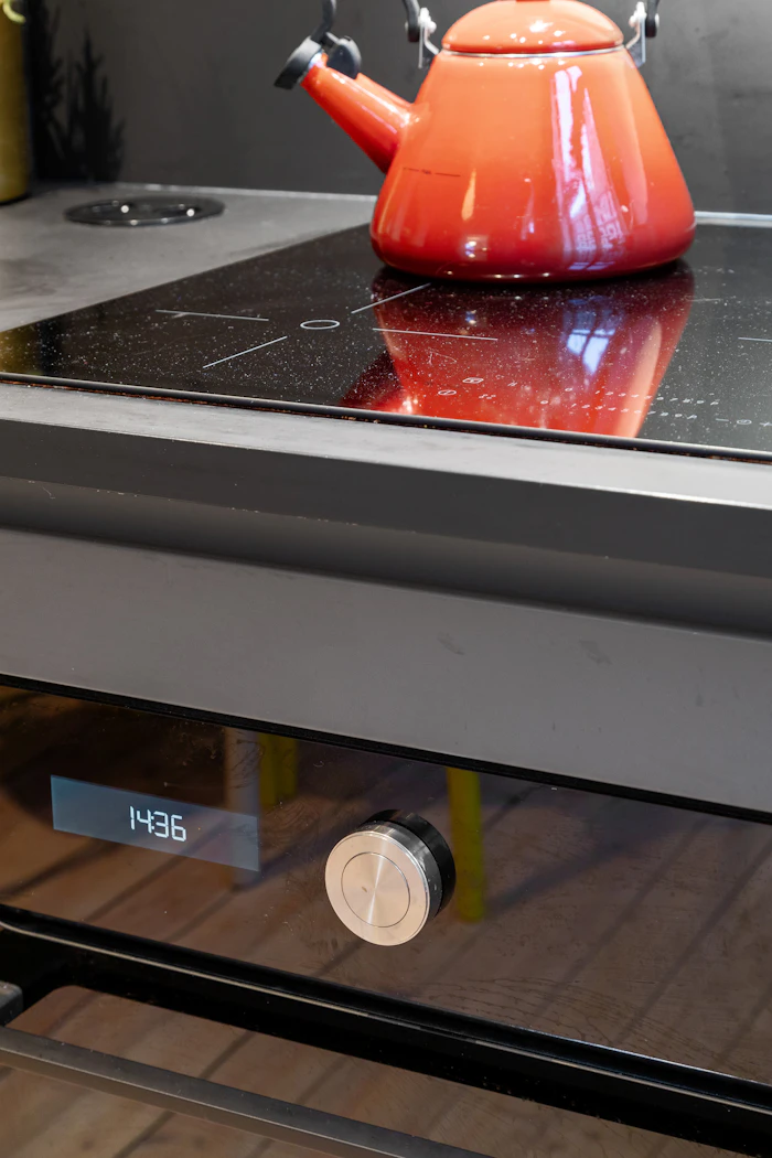 Red kettle on a cooktop in a home kitchen