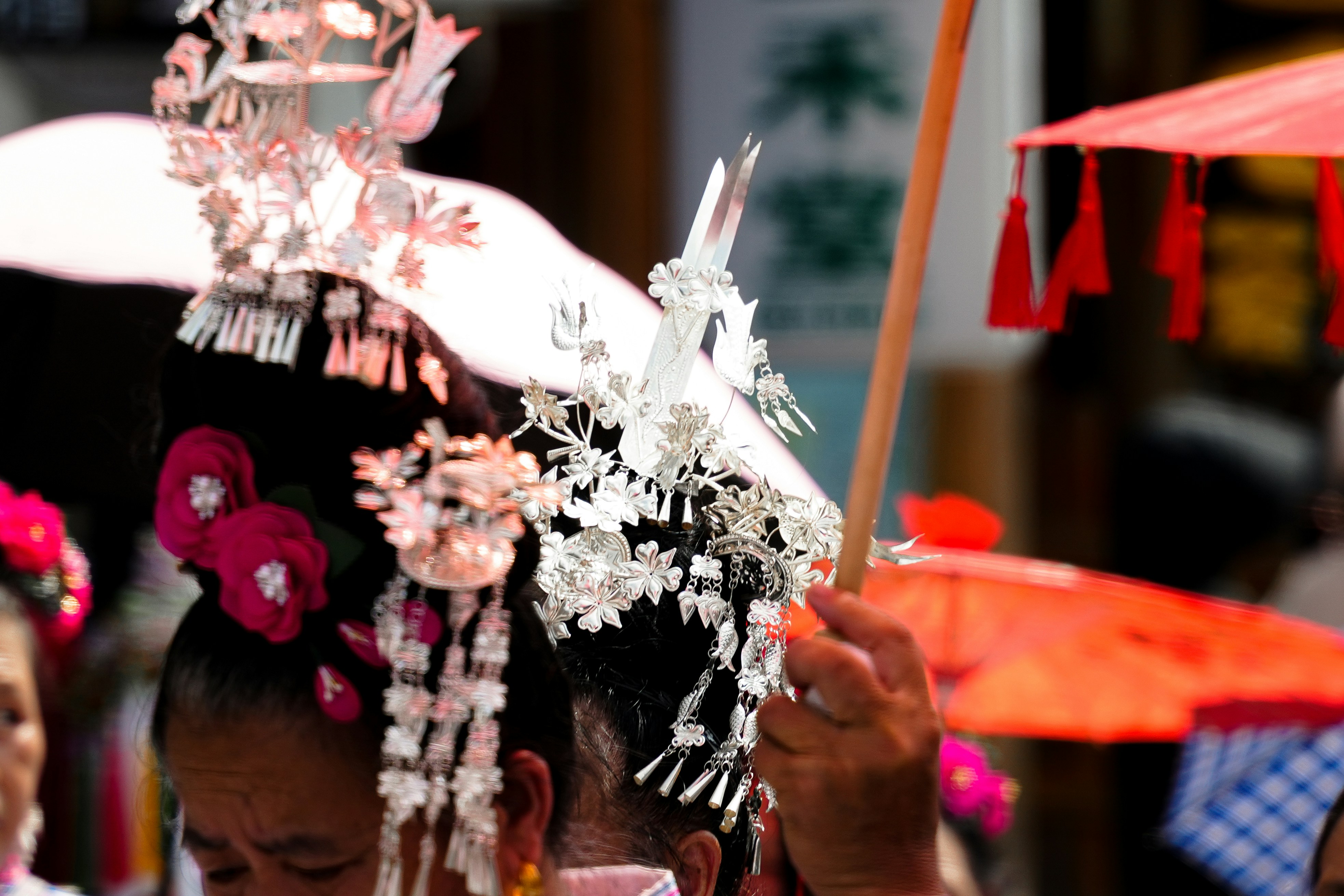 A group of people standing around each other holding umbrellas