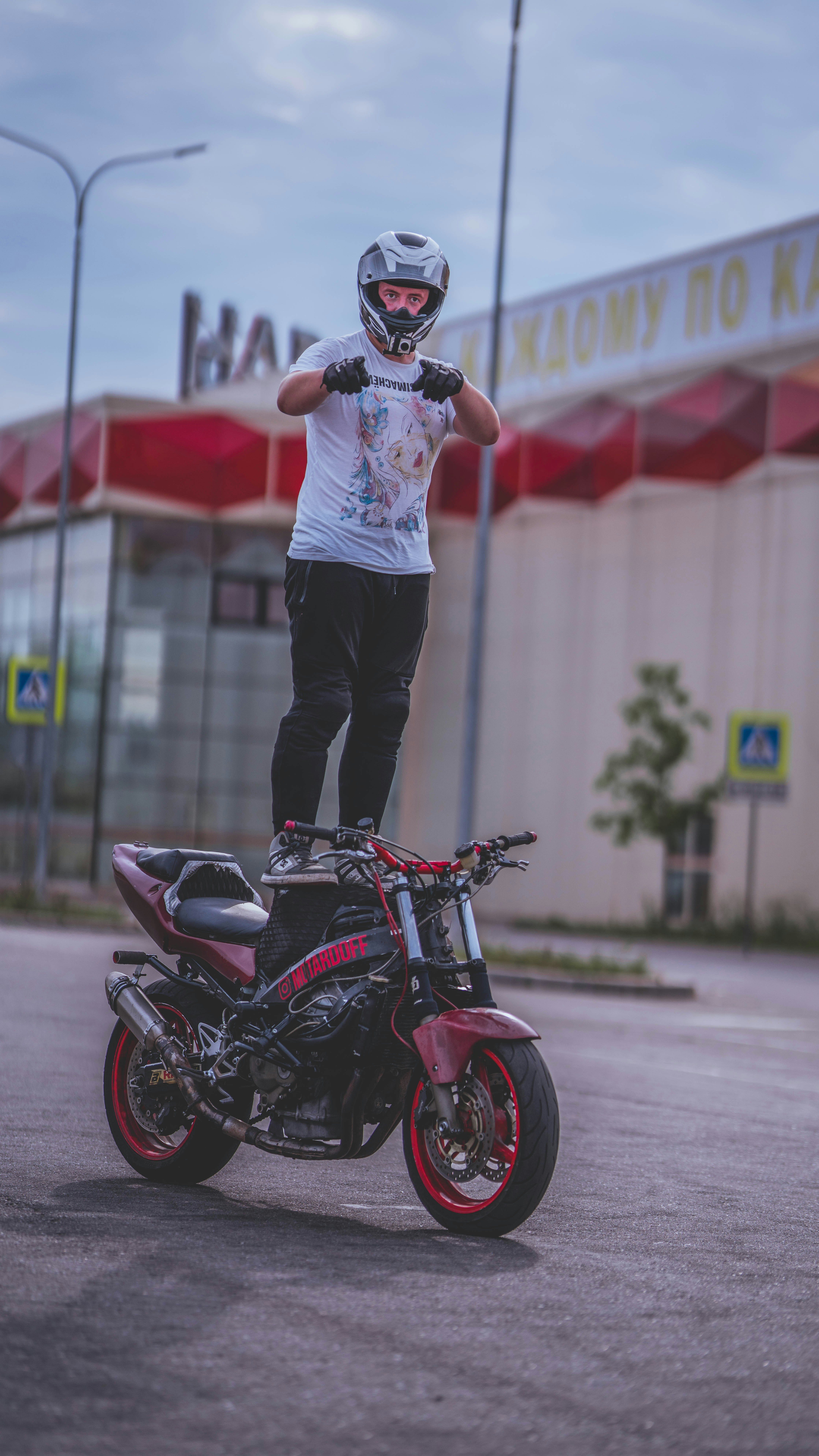 A man standing on top of a motorcycle