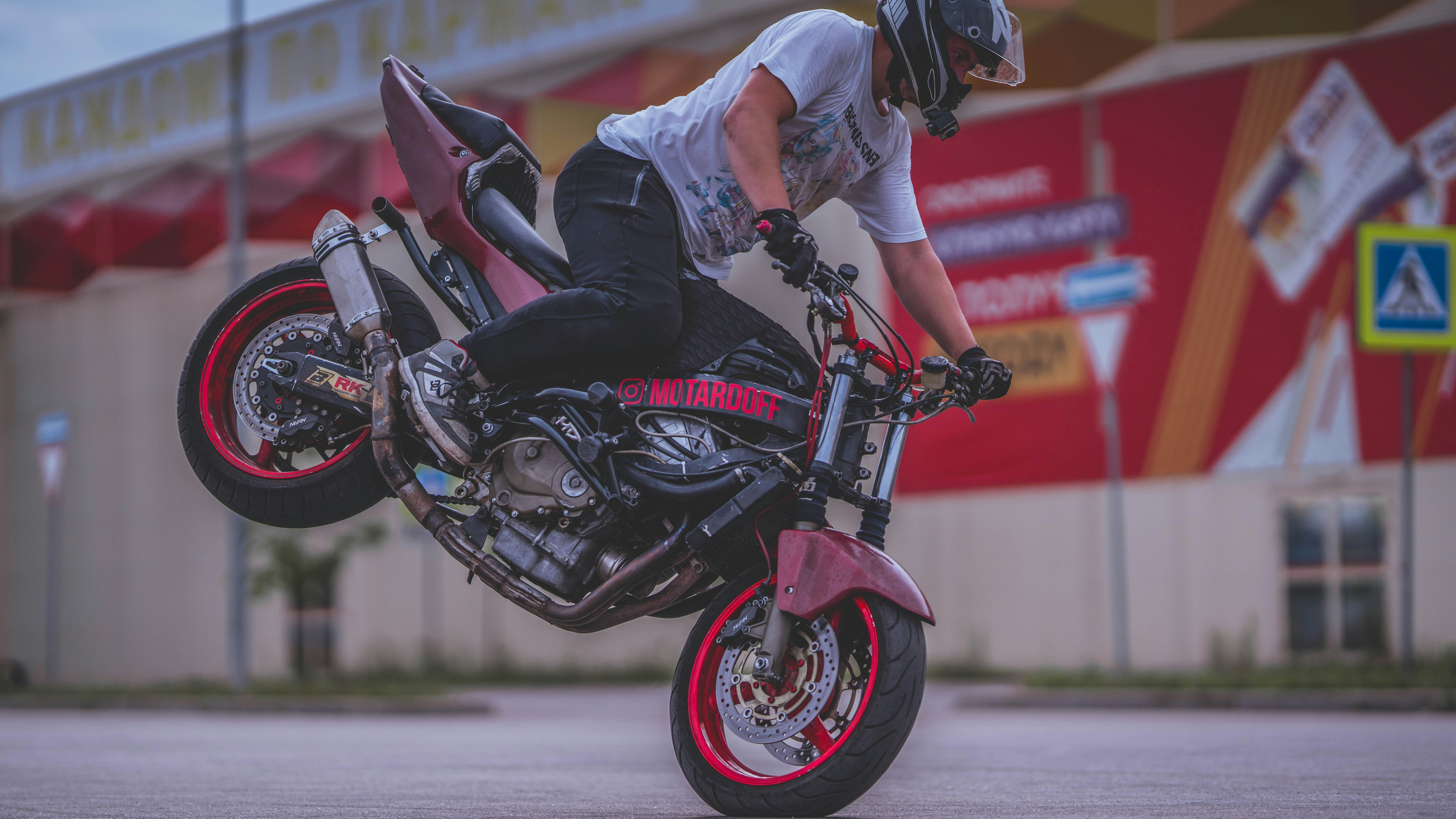 A man is doing a trick on a motorcycle