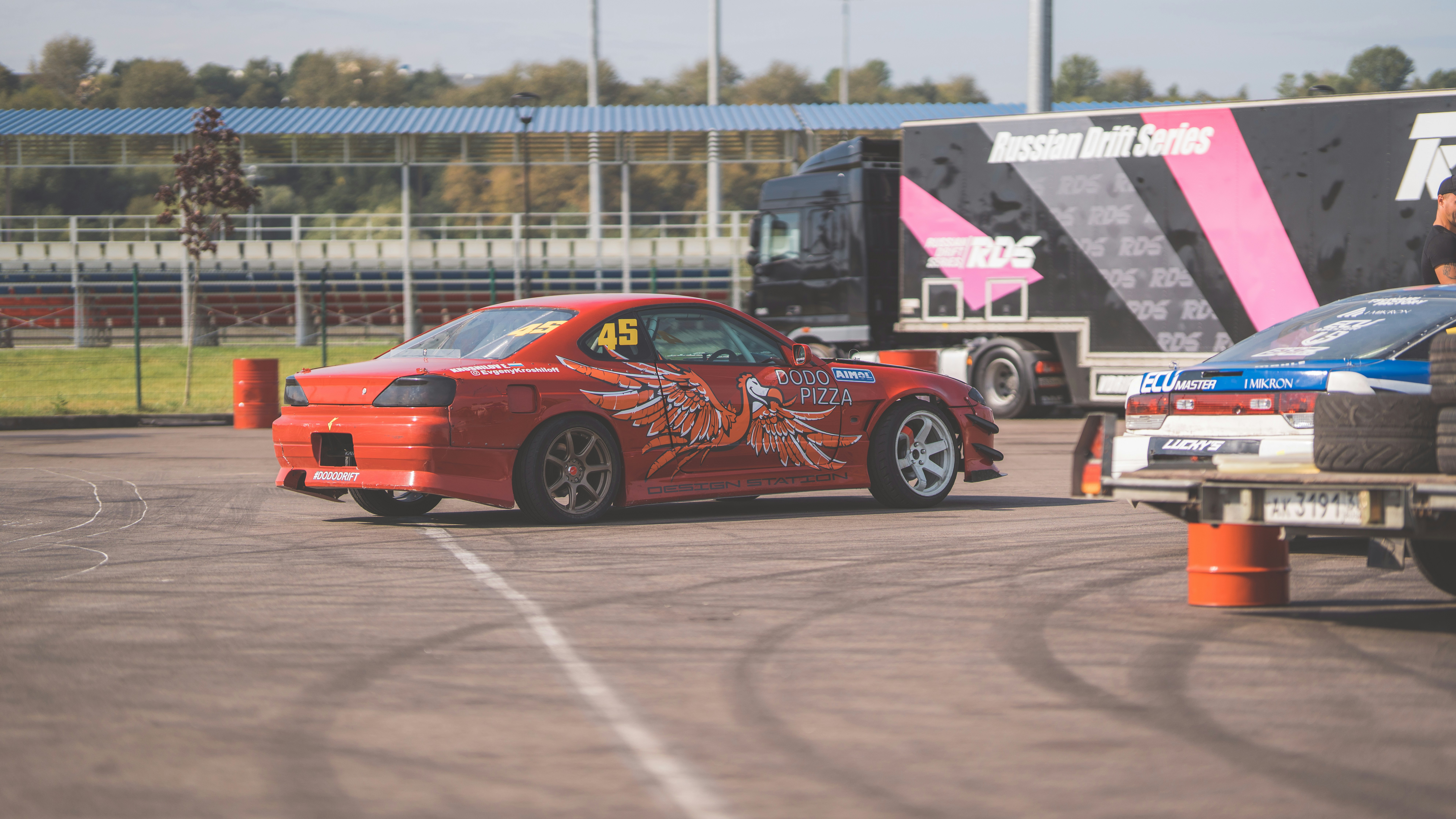 A red sports car driving down a race track
