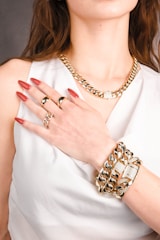 A woman wearing a white dress and gold jewelry