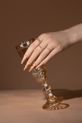 A woman's hand holding a wine glass on a table
