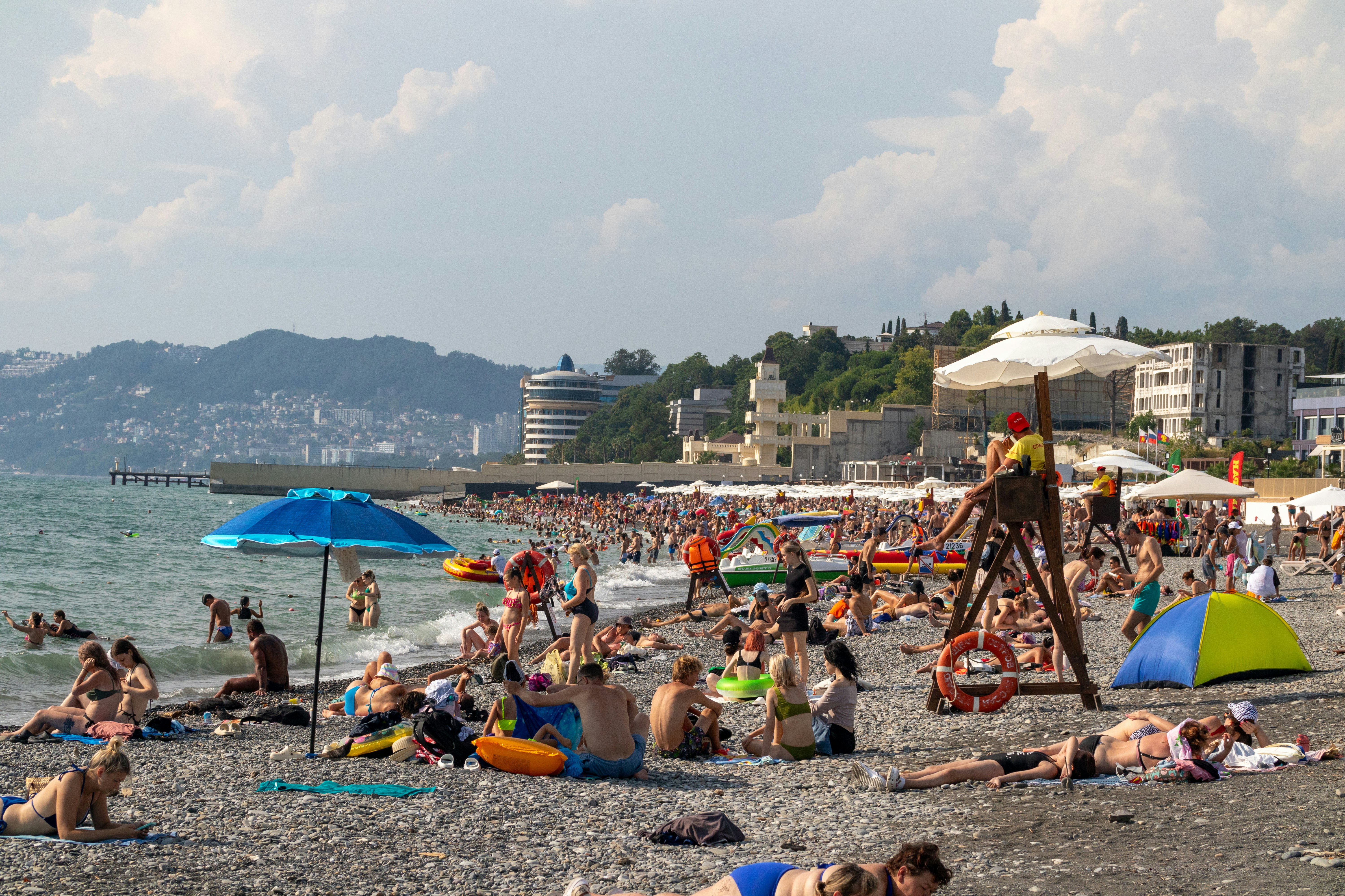 A crowded beach with lots of people on it