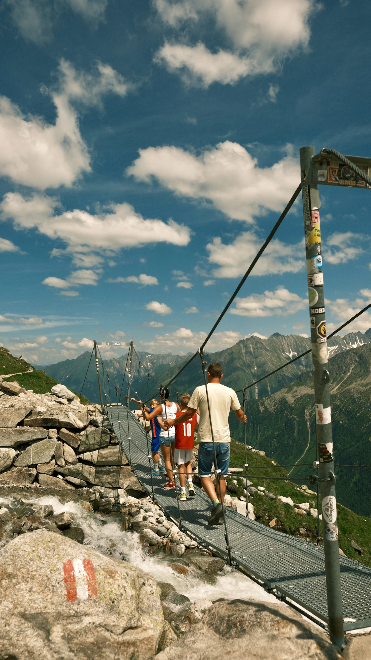A group of people walking across a suspension bridge