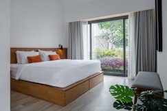 A bedroom with a large bed and a sliding glass door