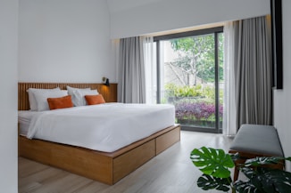 A bedroom with a large bed and a sliding glass door