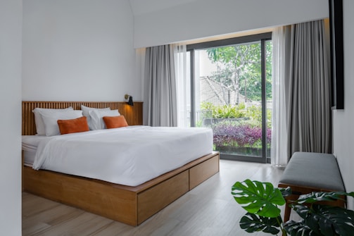 A bedroom with a large bed and a sliding glass door