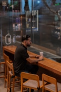 A man sitting at a bar with a cup of coffee