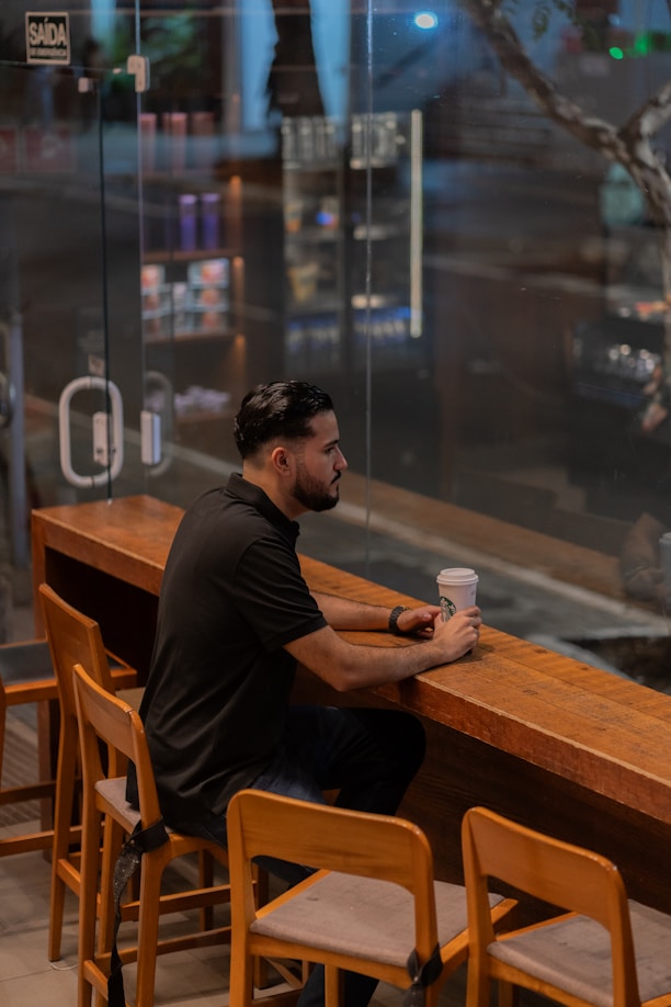 A man sitting at a bar with a cup of coffee