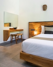 A bedroom with a large bed and a mirror