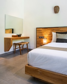 A bedroom with a large bed and a mirror