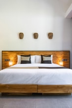A bed with a wooden headboard and two lamps