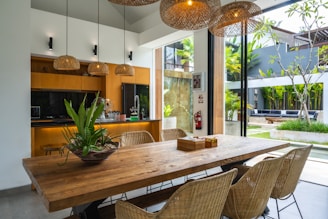A kitchen with a wooden table surrounded by chairs