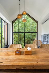A large wooden table in front of a large window