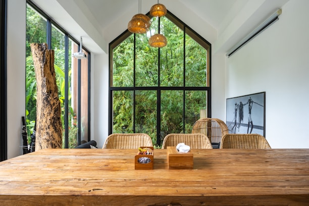 A large wooden table sitting in front of a window