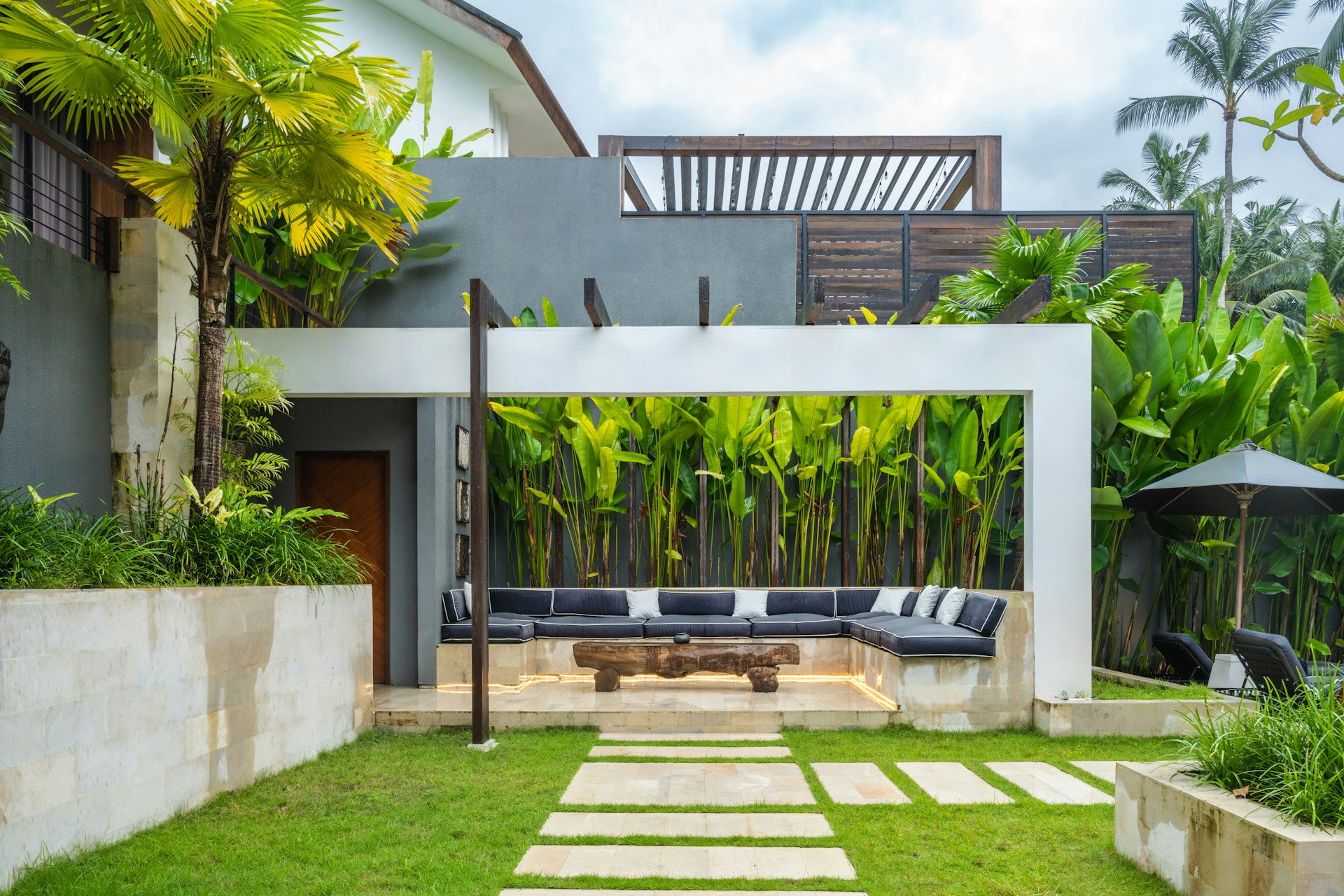 A backyard with a stone path leading to a covered patio