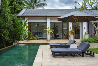 A couple of chaise lounge chairs sitting next to a pool