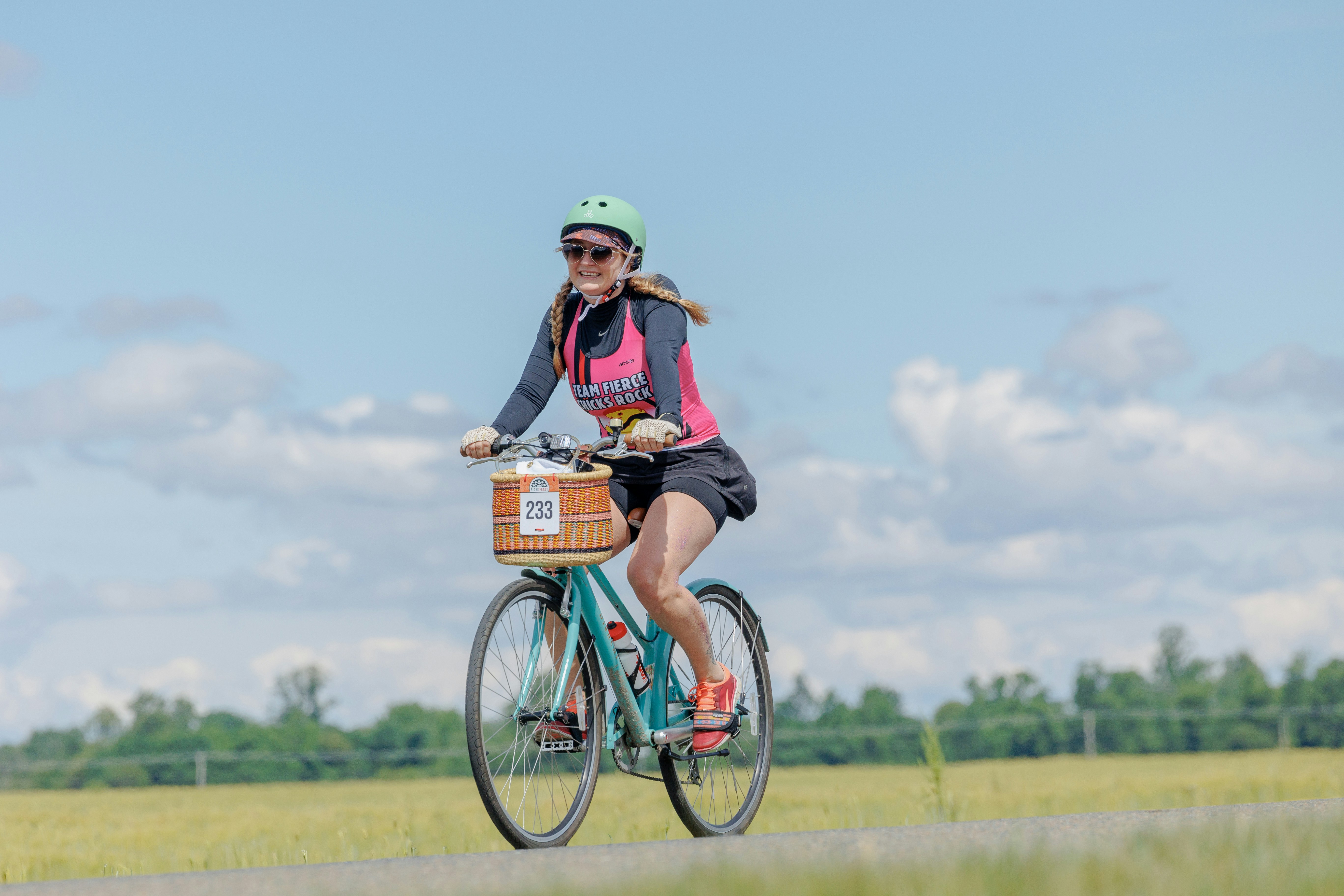A woman riding a bike down a road