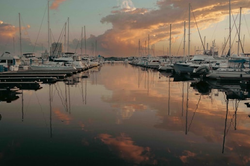 A marina filled with lots of boats under a cloudy sky