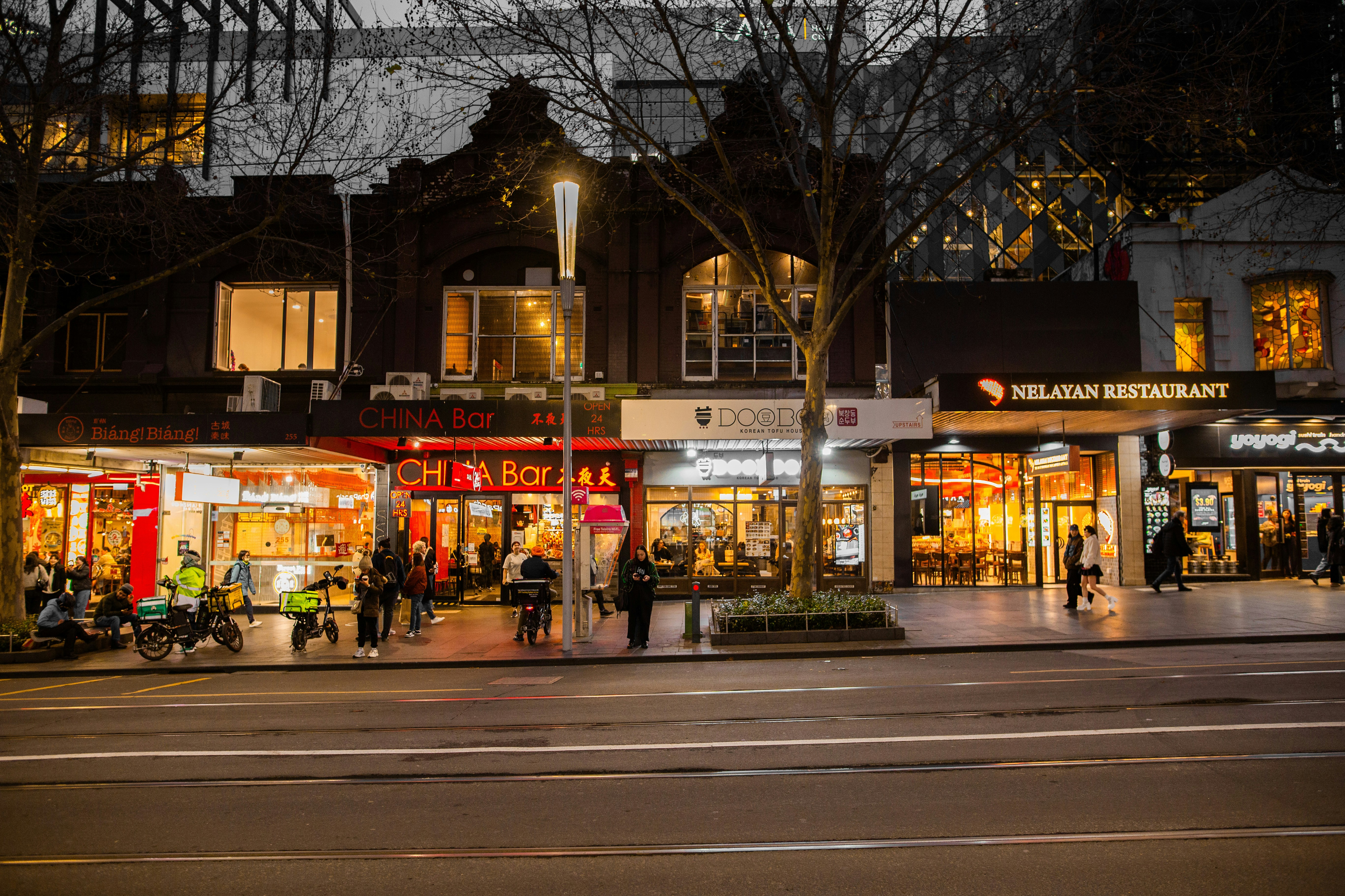 Una strada cittadina di notte con molti negozi
