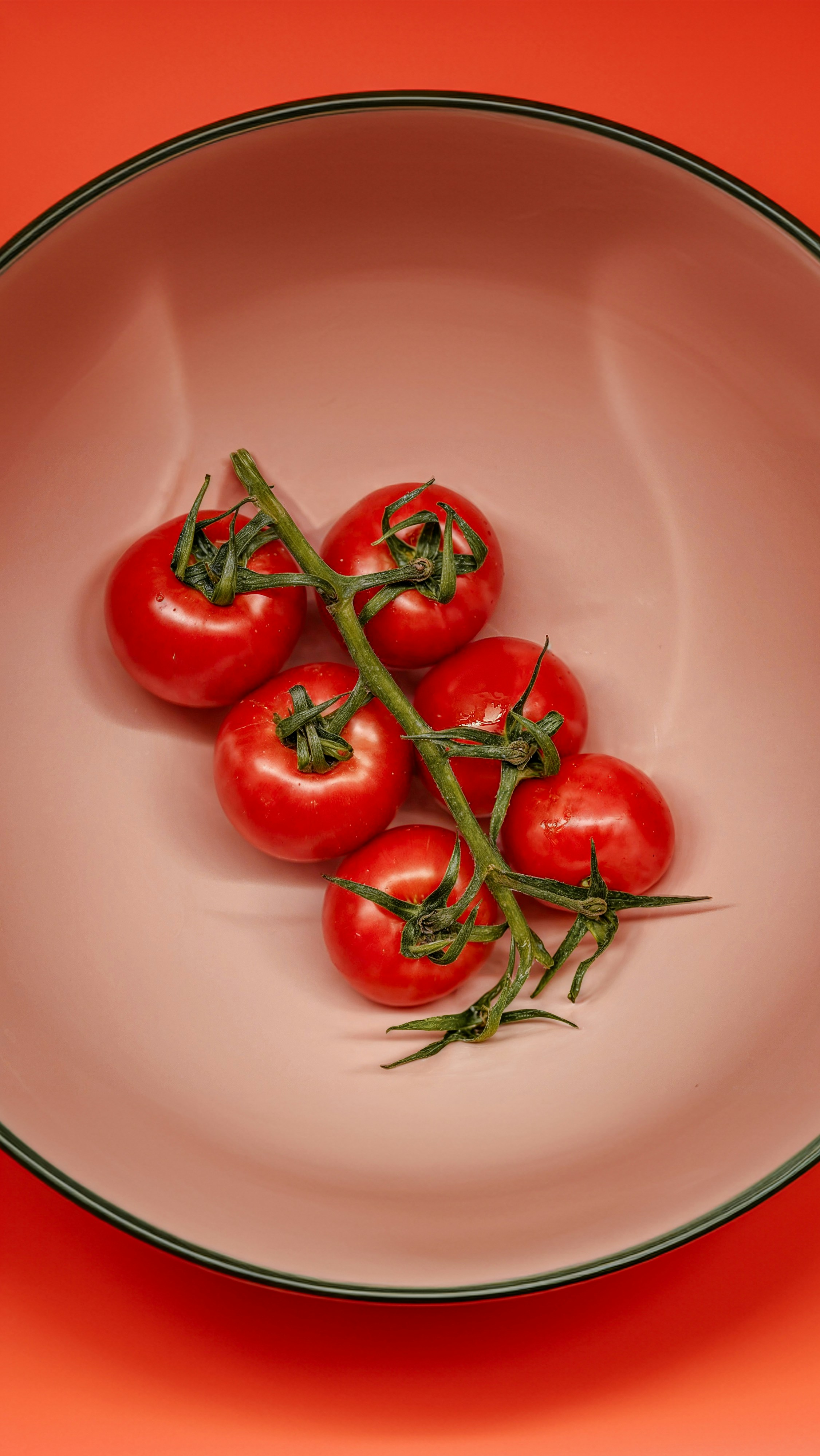 A white bowl filled with tomatoes on top of a table