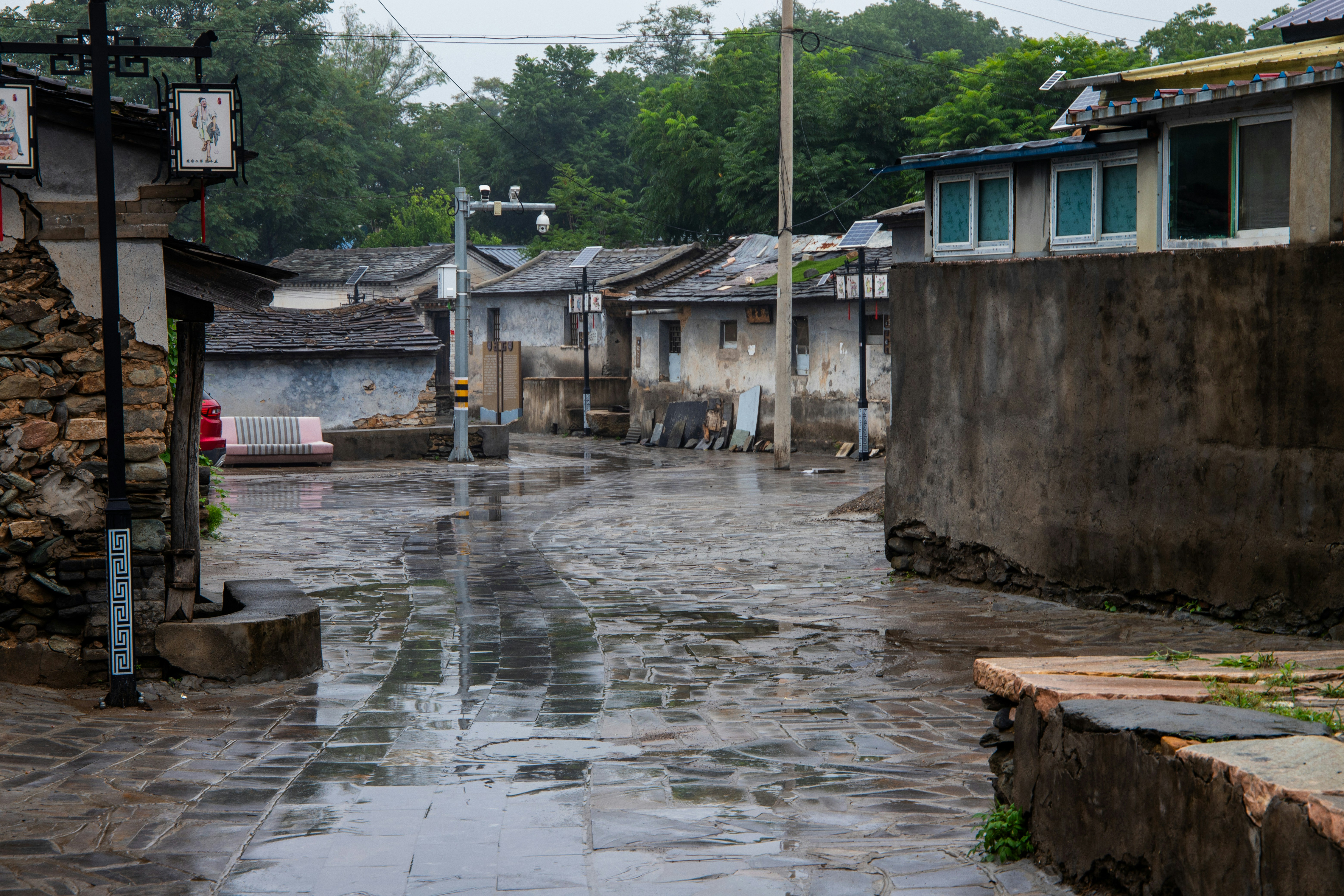A wet street with a person walking down it
