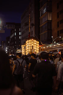 A crowd of people walking down a street at night