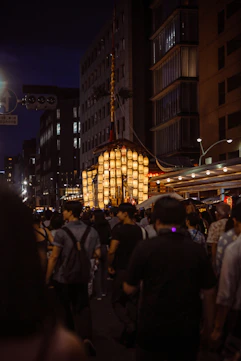A crowd of people walking down a street at night