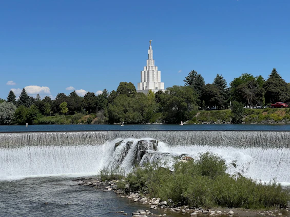 A large waterfall with a church in the background