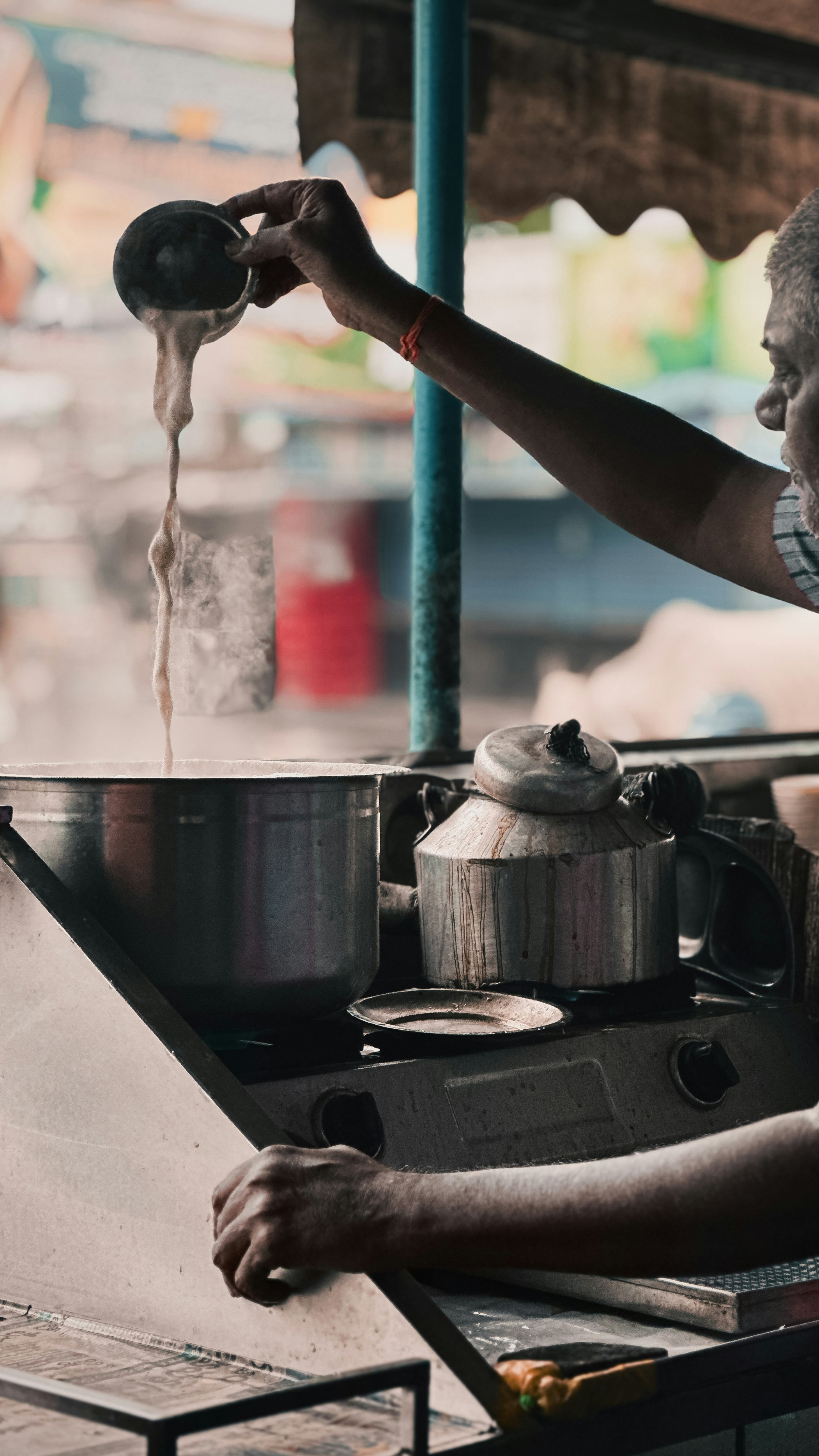 A man pouring water into a pot on top of a stove
