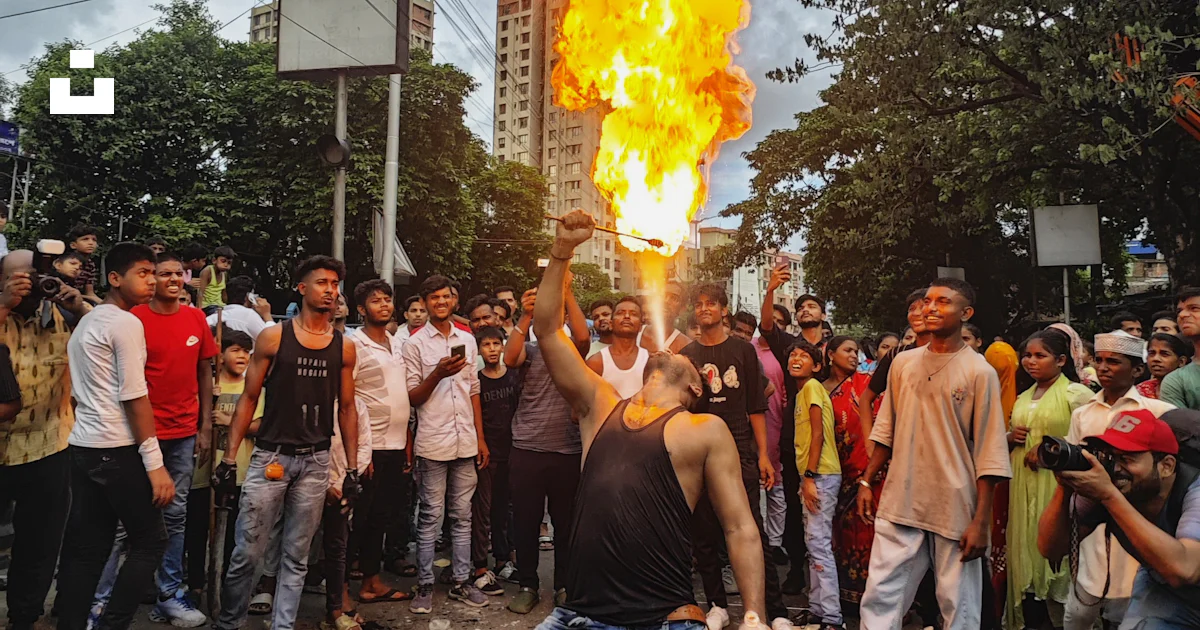 A group of people standing around a burning object photo – Free People ...
