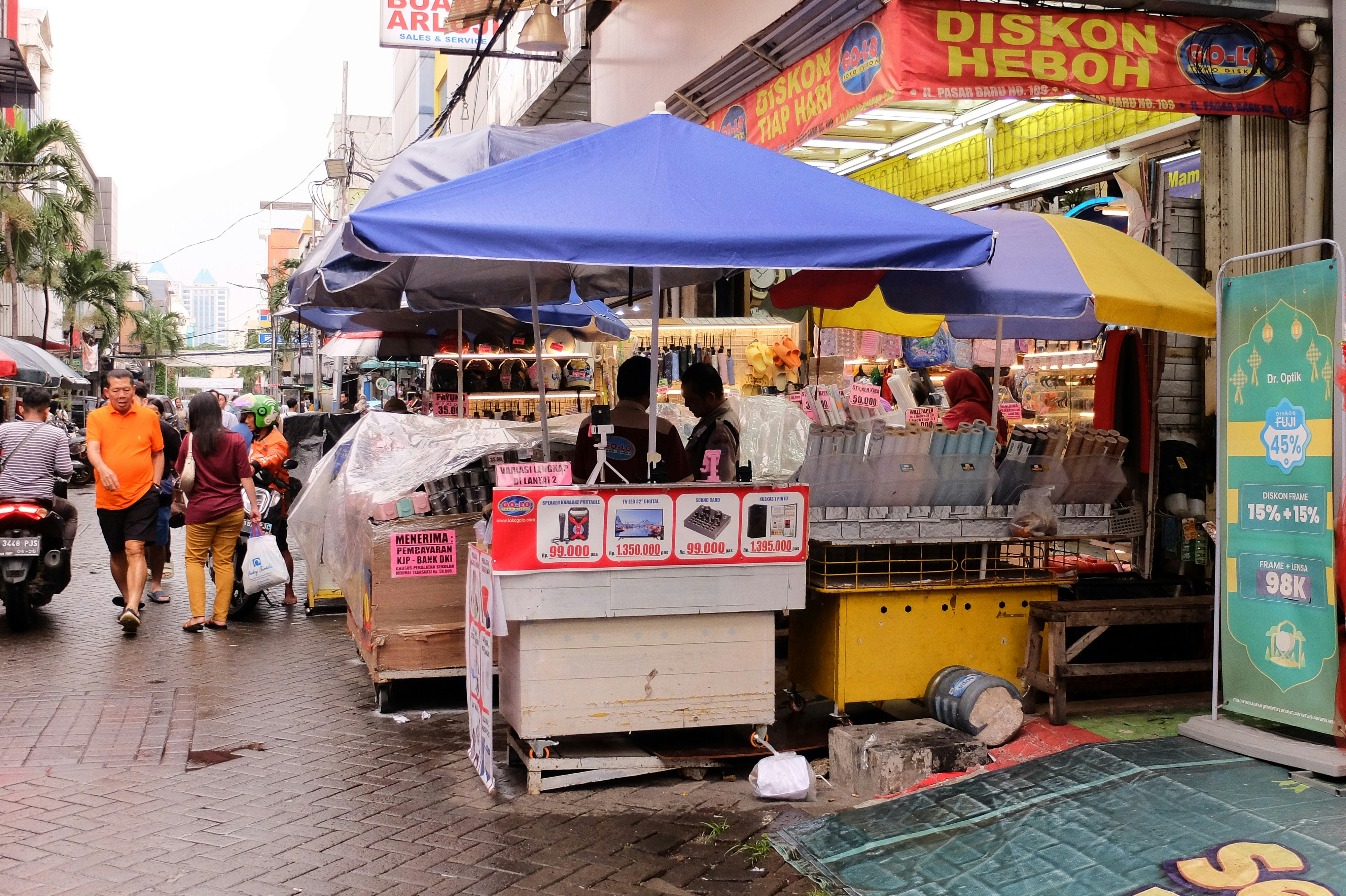 A group of people walking down a wet street