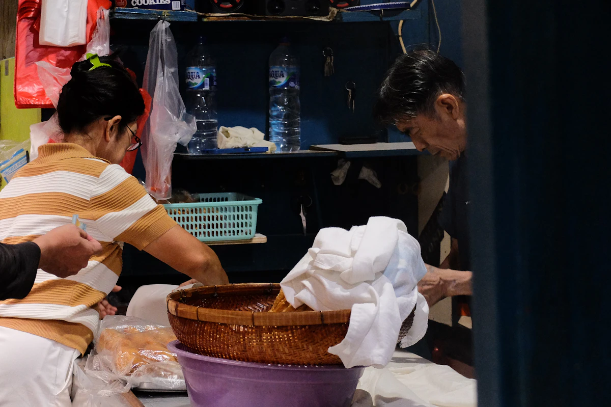 Laundry shop staff preparing neatly folded clothes for customers