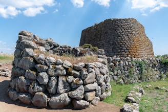 A large stone structure sitting on top of a dirt field