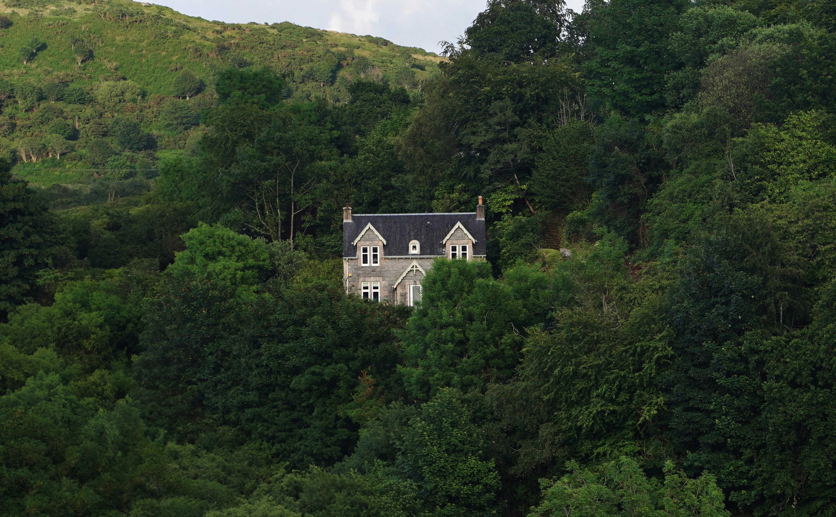 A lonely house in a forest on a hill.