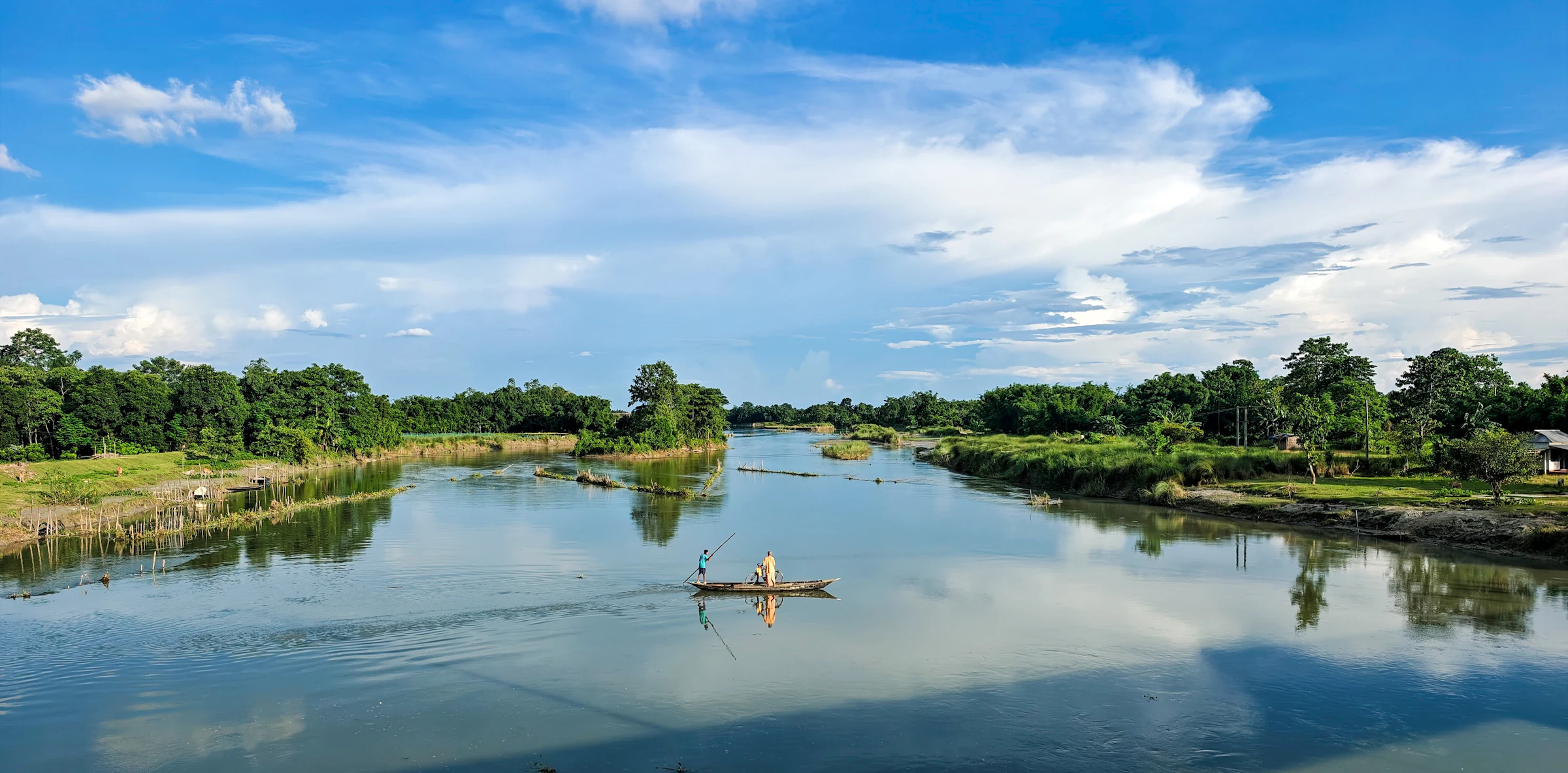 Calm lake surrounded by lush green trees in Bongaigaon, Assam