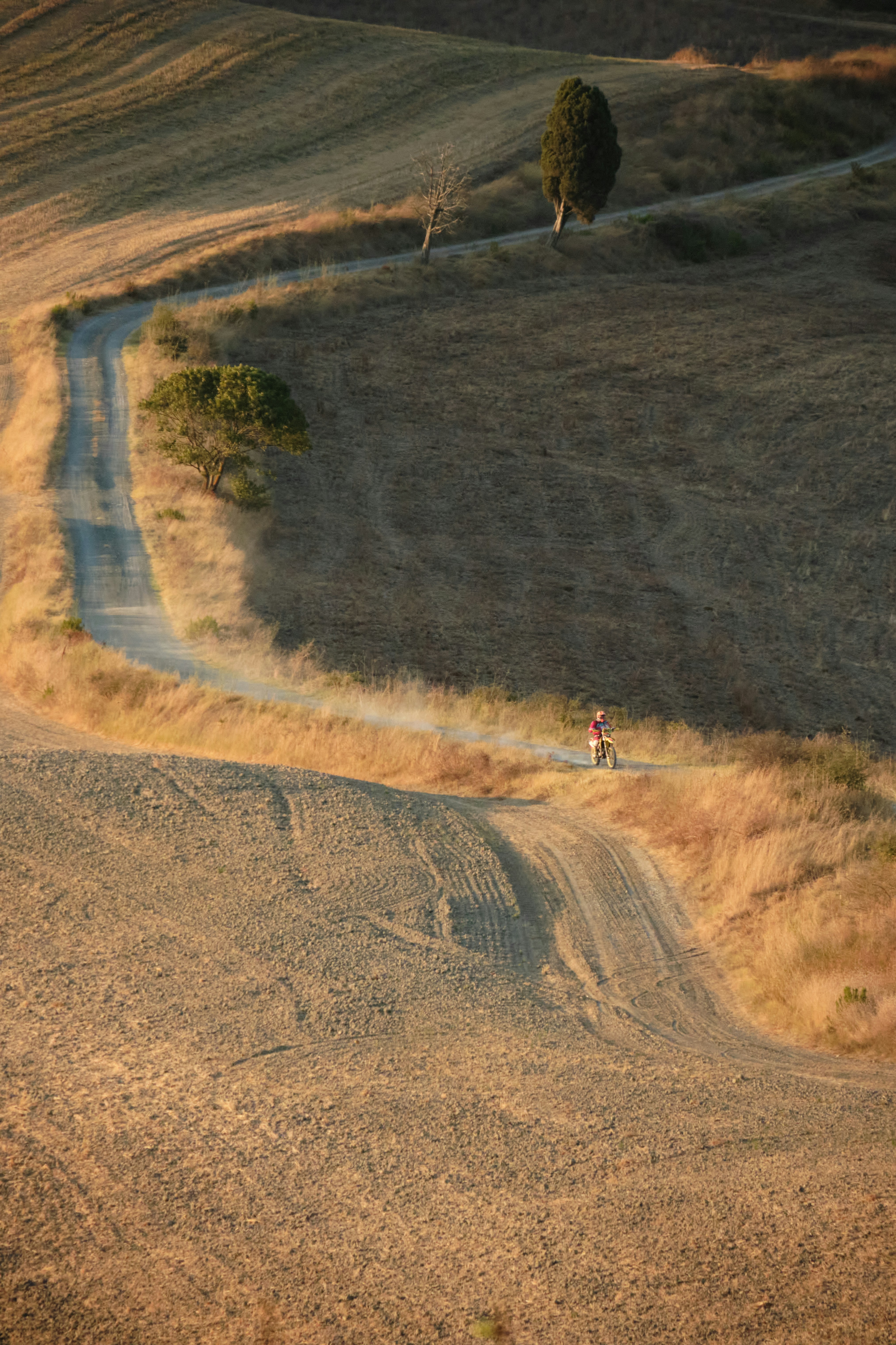 A person riding a bike down a dirt road